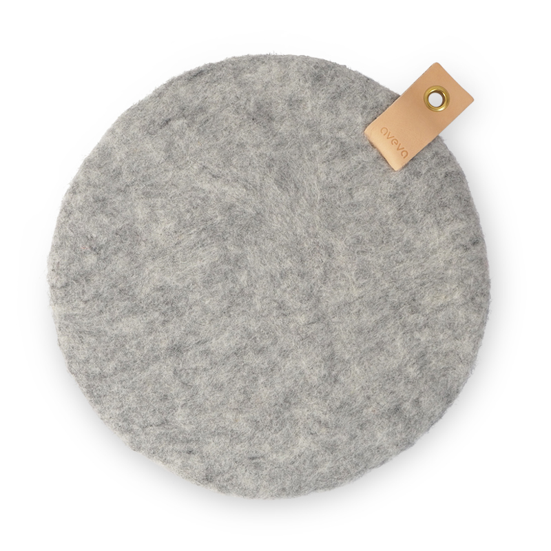 Raw grey seat cushion in wool, dyed with natural colors on one side, and raw wool on the other with a leather band.