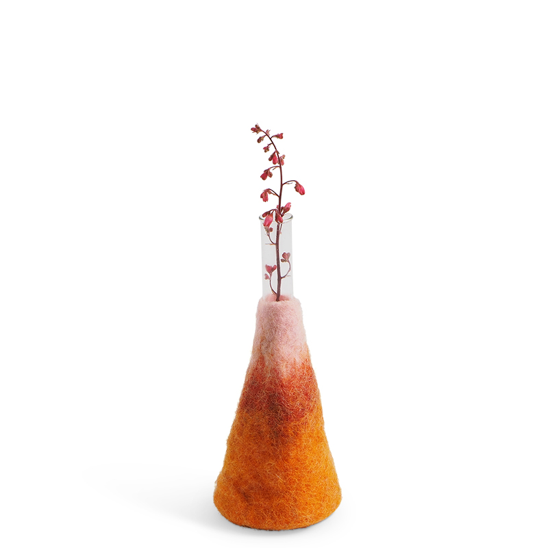 Large orange and pink ombre vase made of wool with a glass for the flowers.
