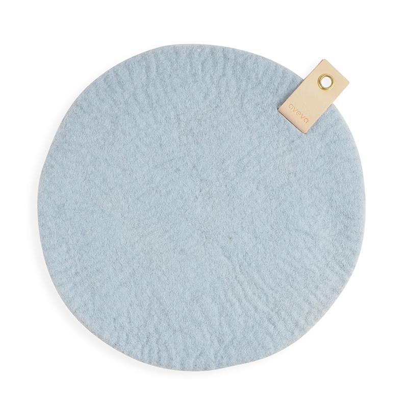 Rund Sittdyna gjord med naturligt färgad med naturliga färger på ena sidan, och rå ull på den andra och har en ekologisk läderdetalj med en metall för upphängning.