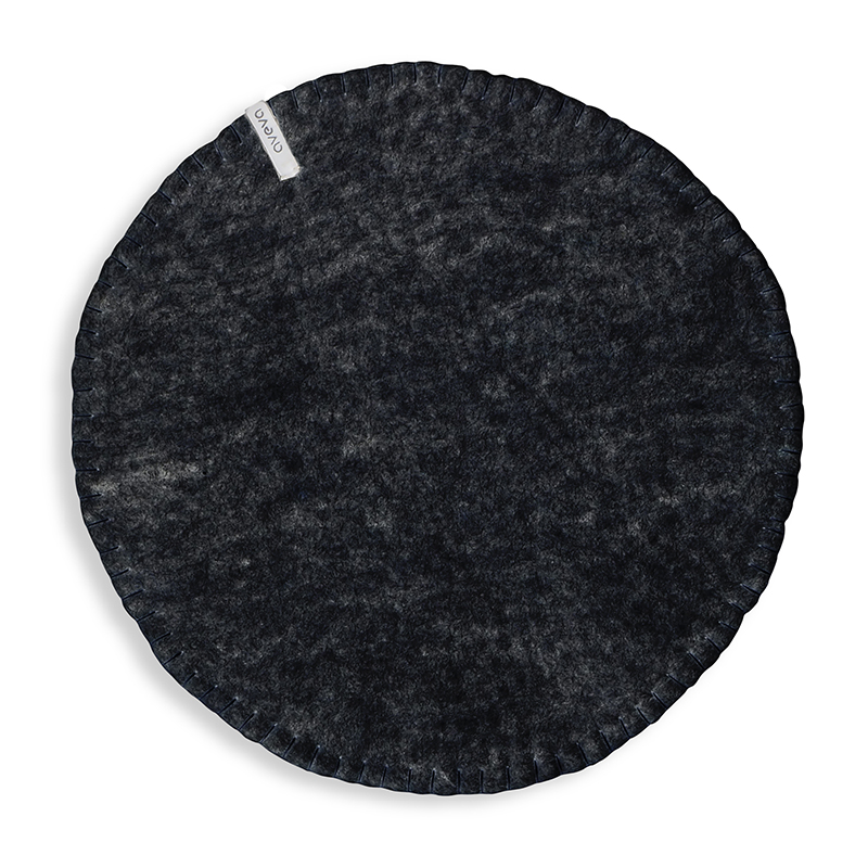 Round raw black seat cushions made with naturally dyed wool features the same colour on the top and underside,  and has a beautiful handstitched rim