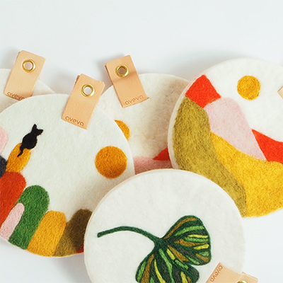 Runda grytunderlägg med ögla i ekologiskt läder som ligger omlott om varandra.