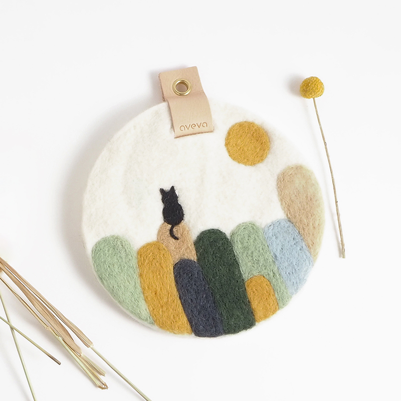 Round trivet with a cat on a hill motif