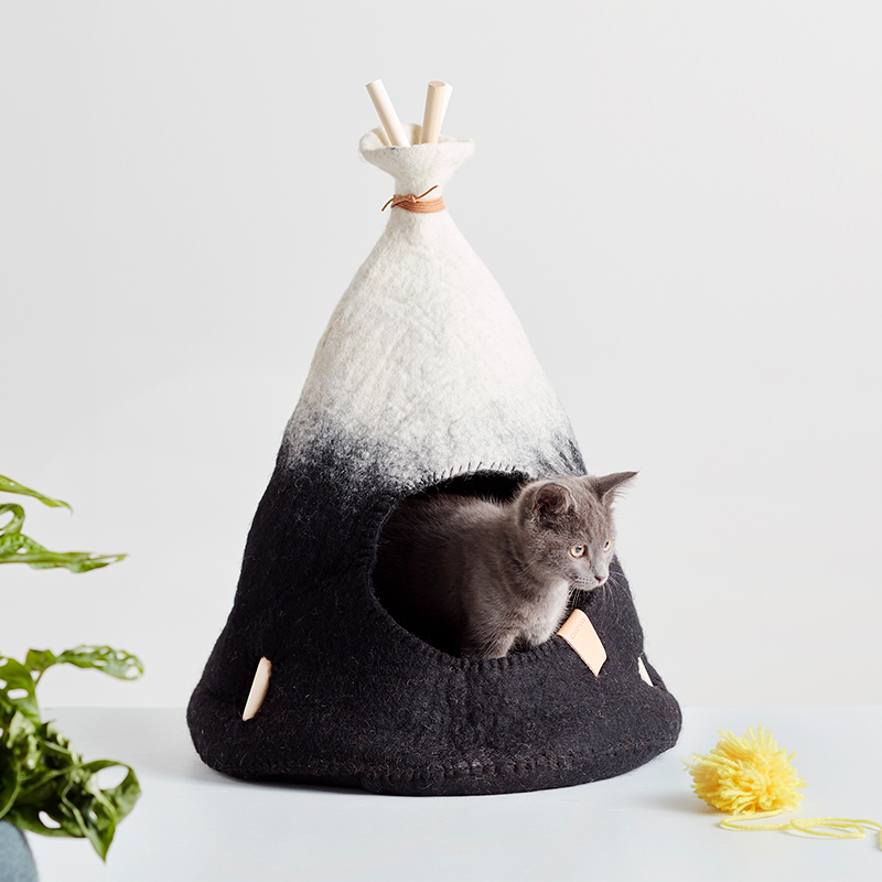 Litet handgjort tipitält i naturvit och svart ombre med en grå kattunge.