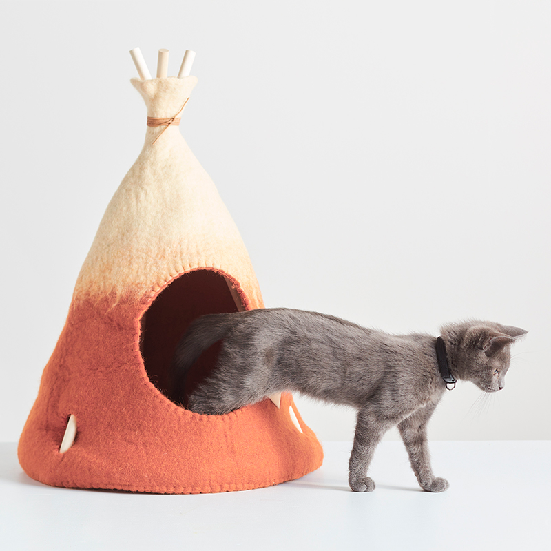 Small handmade tipi tent in natural white and rust ombre with a grey kitten.