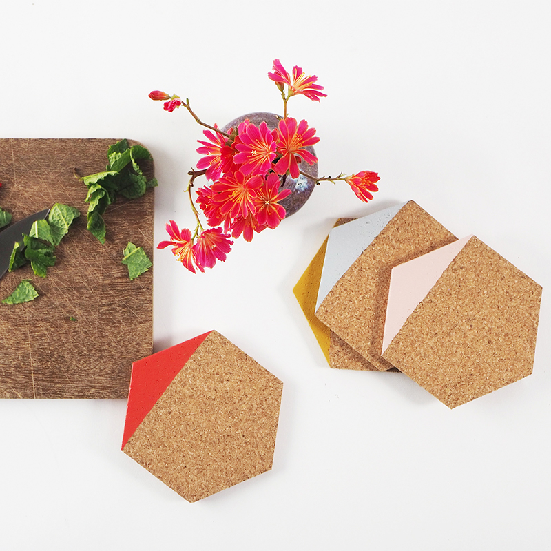 Coasters in light cork dipped in different colors, such as pink, mustard, red and grey.