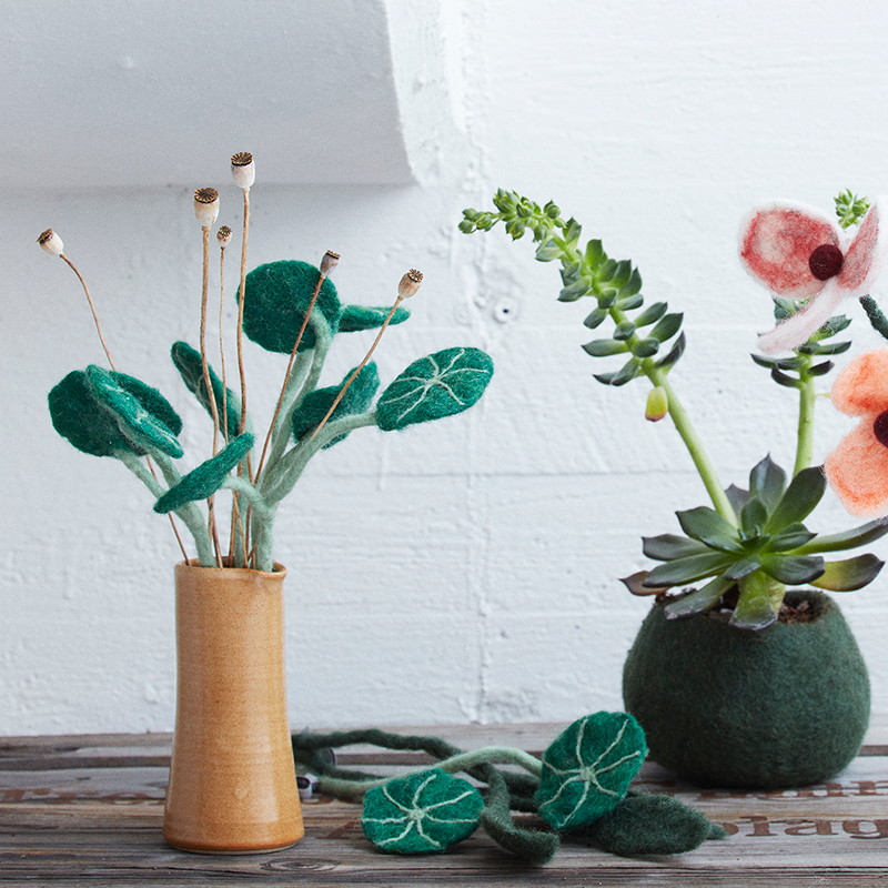 Snittblommor i ull i olika modeller som står upp i en vas.