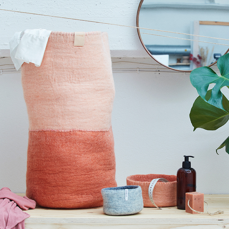 Laundry basket in terracotta with laundry items around.