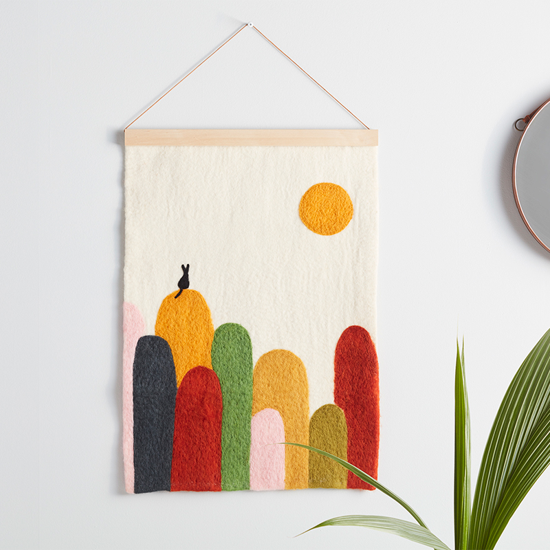 Poster i ull med motiv av en katt sittandes på en kulle