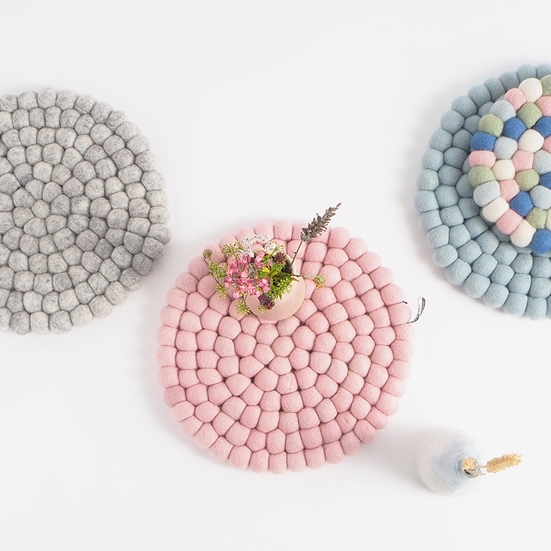 trivets in pink, grey and blue made of wool