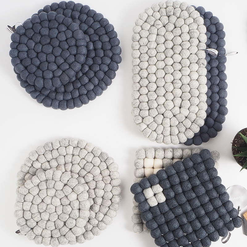 Trivets in wool in different grey colors.