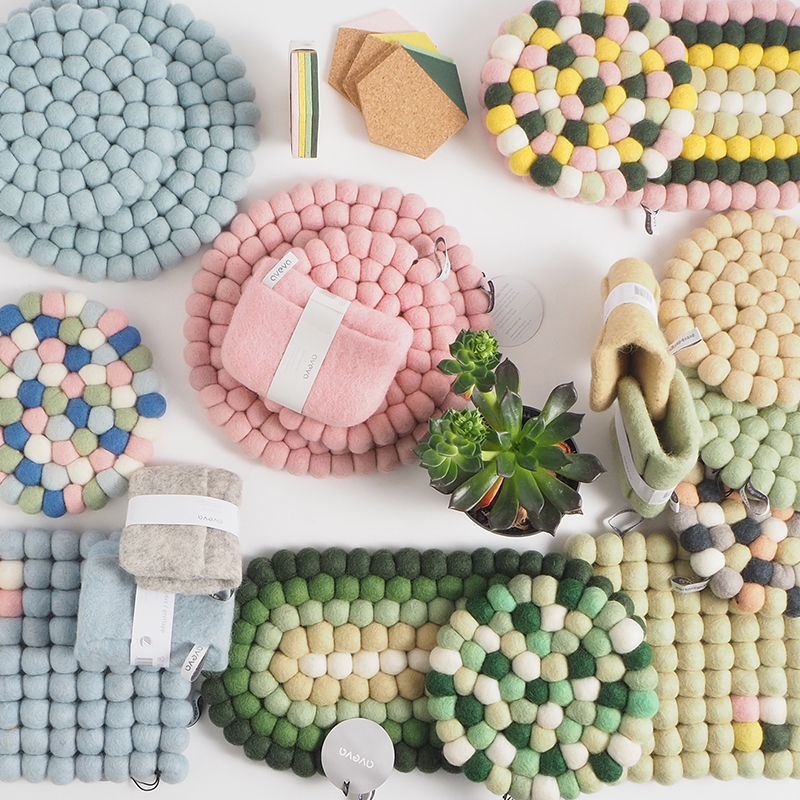 Trivets in pastell colors mixed with potholders in a pile in wool