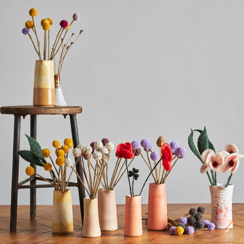 Cut flowers in wool in different models that stand up in a flower bed.