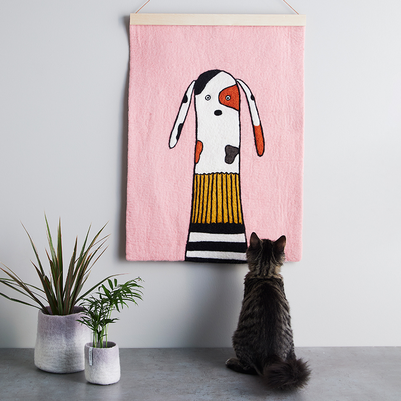 Affish i ull med motiv av en hund och en katt som tittar på affischen.