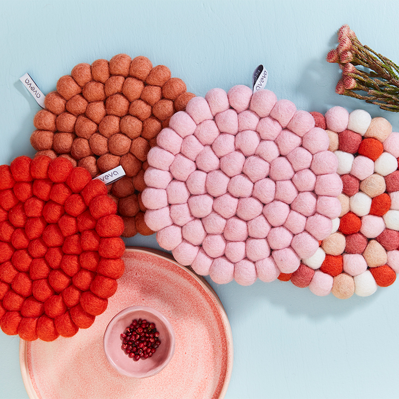 Trivets in wool in different pink, rust and red colors.