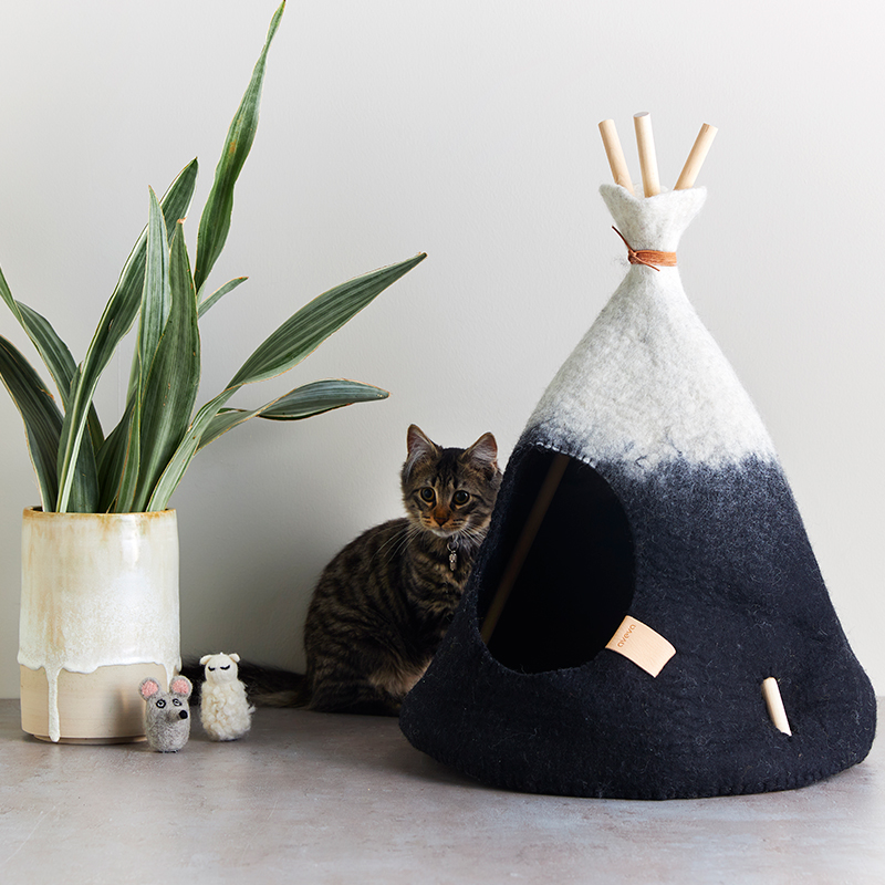 Small handmade tipi tent in natural white and black ombre with a grey kitten.