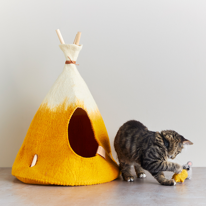 Small handmade tipi tent in natural white and mustard ombre with a grey kitten.