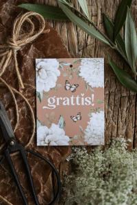 Maja Gåvokort - Grattis (Vita blommor på ockra bakgrund)