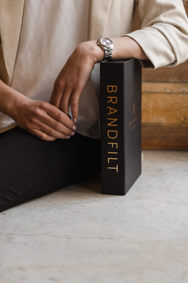 Brandfilt i bokbox svart med guldtext. Brandflit i snyggt bokomslag