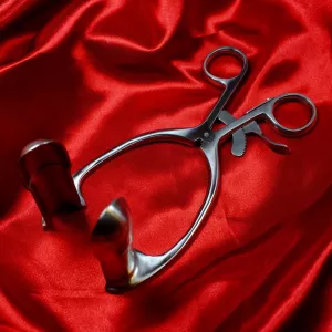 Two‑piece satin‑polished anal speculum in stainless steel from Chambers of Love, open on a red background – a medical fetish sex toy within BDSM.