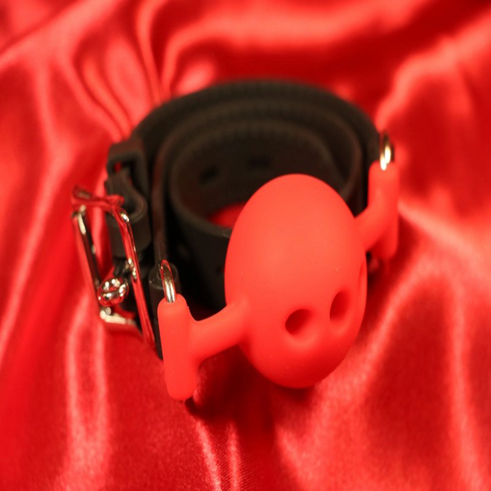 Röd andningsbar silikon boll-gag i storlek L från Chambers of Love. Designad för komfort och säkerhet under längre sessions. Perfekt för BDSM-utlevnad och rollspel. Artikelnummer MWX2122RL.