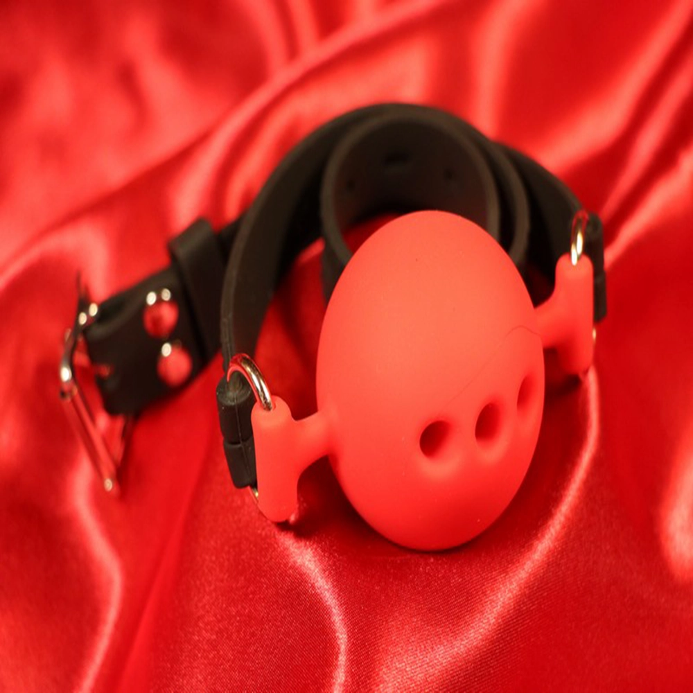 Röd andningsbar silikon boll-gag i storlek M från Chambers of Love. Designad för komfort och säkerhet under längre sessions. Perfekt för BDSM-utlevnad och rollspel. Artikelnummer MWX2122RM.