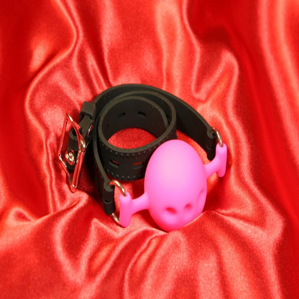 Rosafärgad andningsbar silikon boll-gag i storlek M från Chambers of Love. Designad för komfort och säkerhet under längre sessions. Perfekt för BDSM-utlevnad och rollspel. Artikelnummer MWX2122PIM.