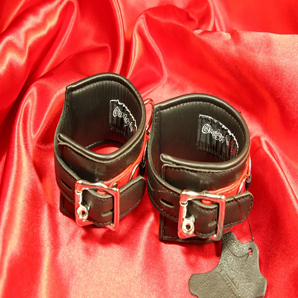 Detaljbild av det låsbara spännet på de röd-svarta BDSM-handbojorna. En säker och stilfull design från Chambers of Love, perfekt för lek och kontroll.