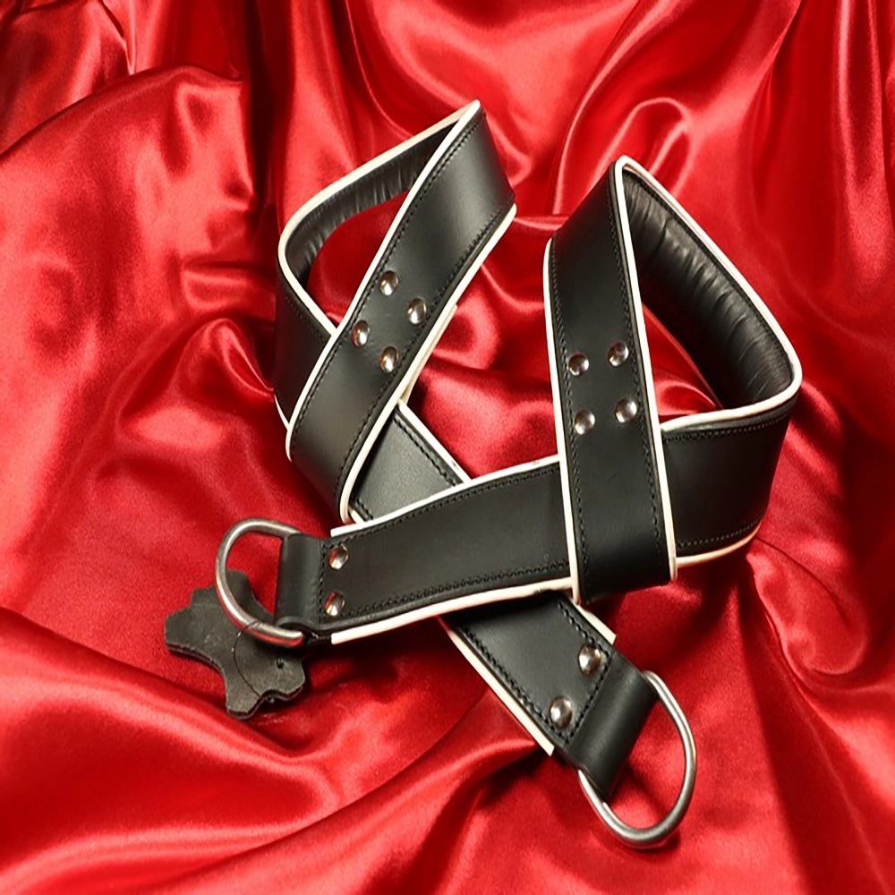 Svart vadderad BDSM-boja med vit kant från Chambers of Love. Lyxig, bekväm och exklusiv design ur vårt premiumsortiment.