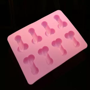 Penis-shaped ice tray in pink silicone from Chambers of Love – mold for ice or chocolate with penis-shaped cavities on a dark background