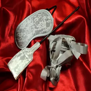 Lace Bondage Kit for beginners from Chambers of Love. Blindfold, handcuffs, and small paddle on a red background. Elegant and playful starter set for sensual bondage.