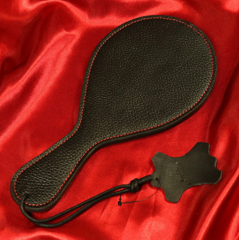 Leather Paddle Ping Pong from Chambers of Love, article number XB134 – a sleek and elegant paddle with red stitching. Perfect for intense over-the-knee BDSM sessions, designed to deliver both precision and power with every strike.