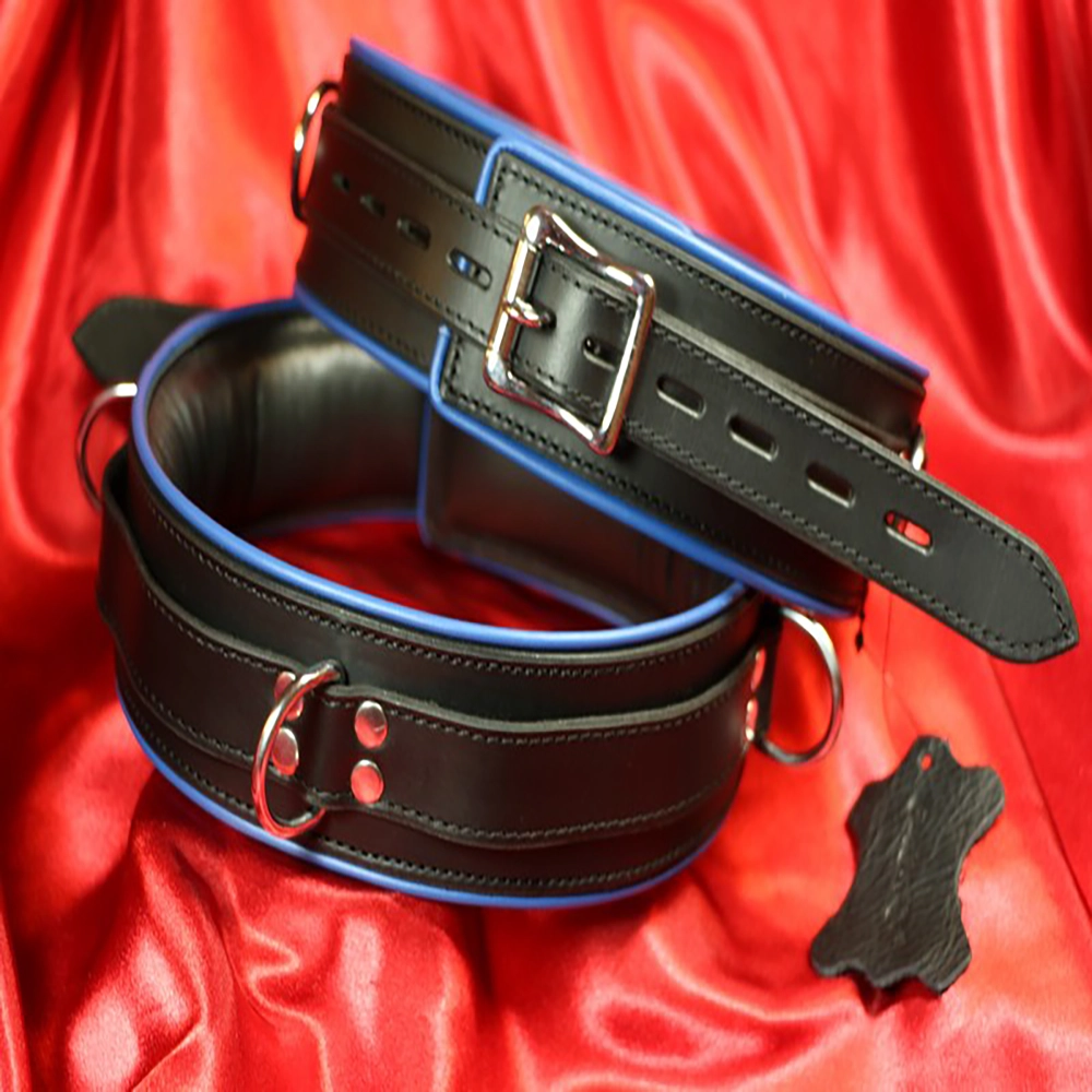 Exklusive, gepolsterte BDSM-Oberschenkelmanschetten aus schwarzem Premiumleder mit blauem Rand von Chambers of Love. Luxuriöses, bequemes und elegantes Design aus unserer Premiumkollektion.