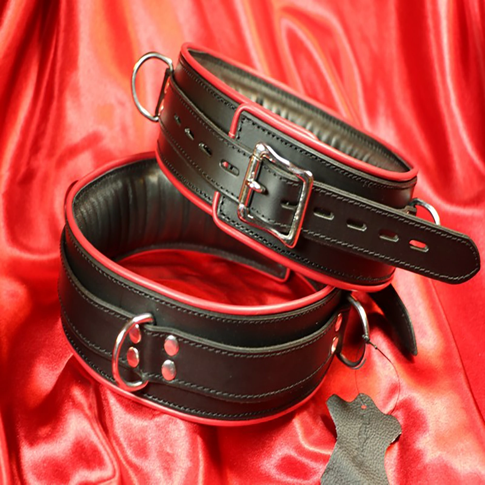Schwarze, gepolsterte BDSM-Fessel mit rotem Rand von Chambers of Love. Luxuriöses, bequemes und exklusives Design aus unserer Premiumkollektion.