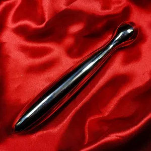 Luxurious stainless steel dildo from Chambers of Love, lying on a red background that highlights the high-gloss metal surface and rounded bulb.