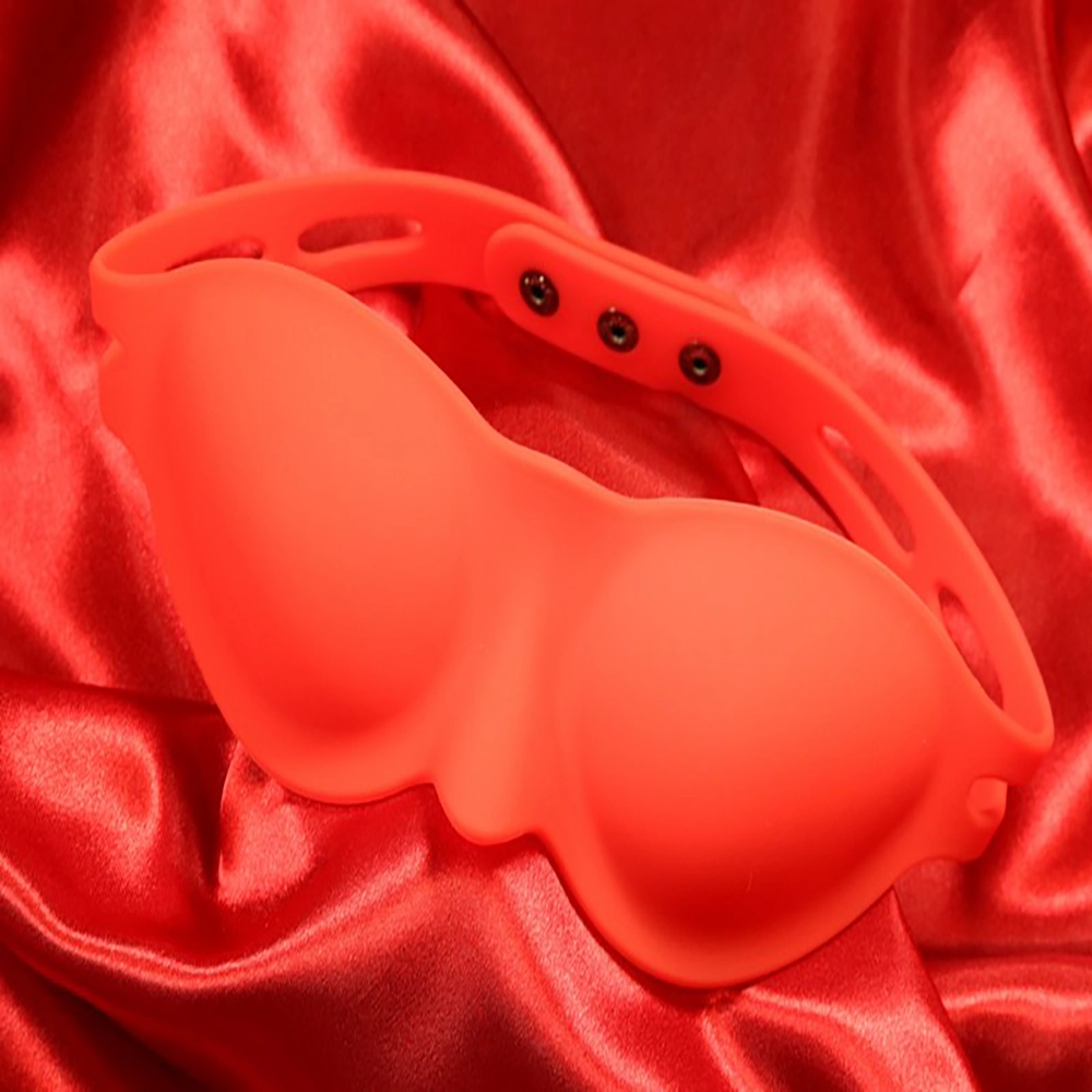 Yksityiskohtakuva punaisesta silikonisesta silmänaamiosta Chambers of Lovelta, kuvattu edestä punaista taustaa vasten.