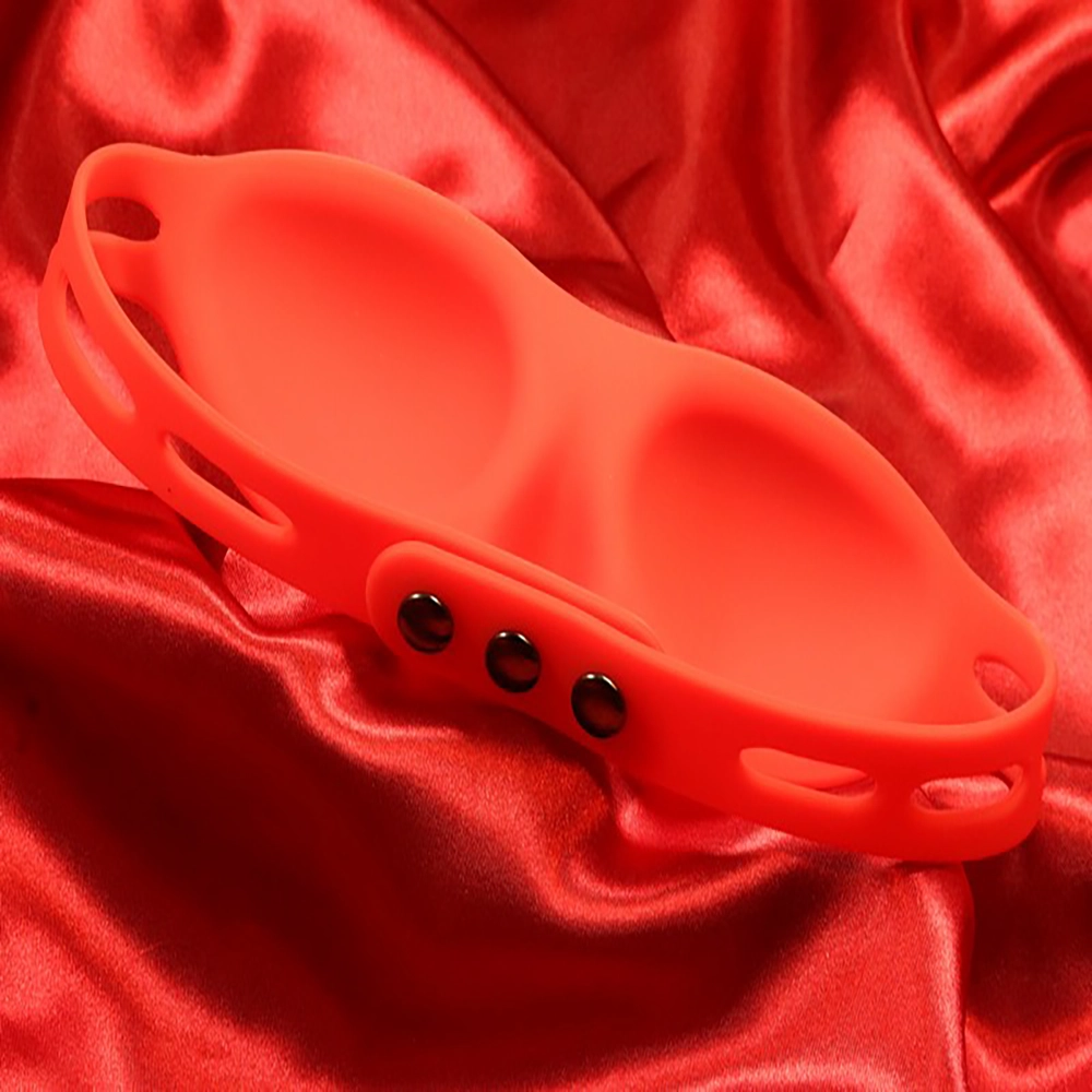 Nopea kiinnitys punaisessa silikonisessa silmänaamiosta Chambers of Lovelta, kuvattu punaista taustaa vasten.