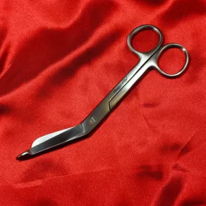 Säkerhetssax 140 mm från Chambers of Love på röd satintygg, utan fodral. Säkerhetssax för säker bondage och snabb frigöring vid panik eller kramp.