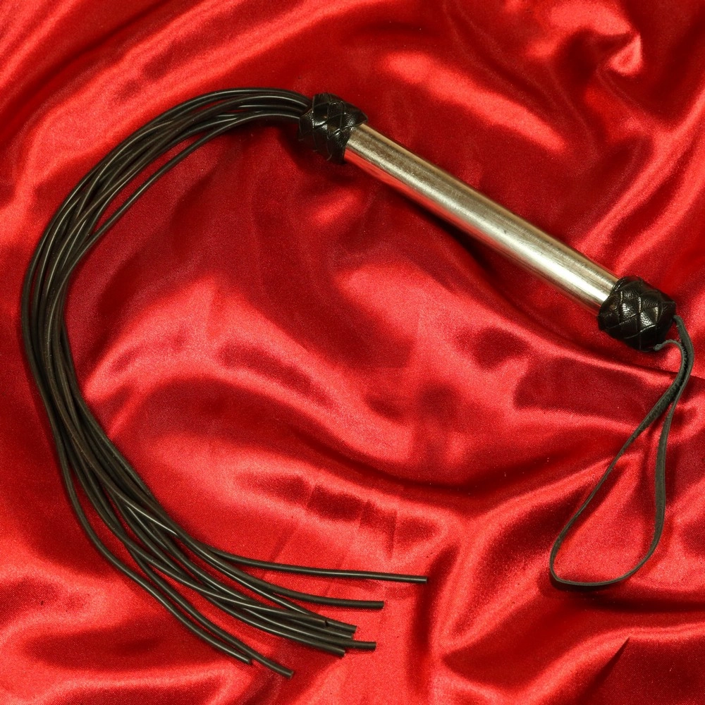 Silicone Flogger Chambers of Lovelta, mustat kumihännät ja kiiltävä teräskahva. Täydellinen intensiivisiin ja tyylikkäisiin BDSM-hetkiin sekä nautintoon märkätiloissa tai rannalla.