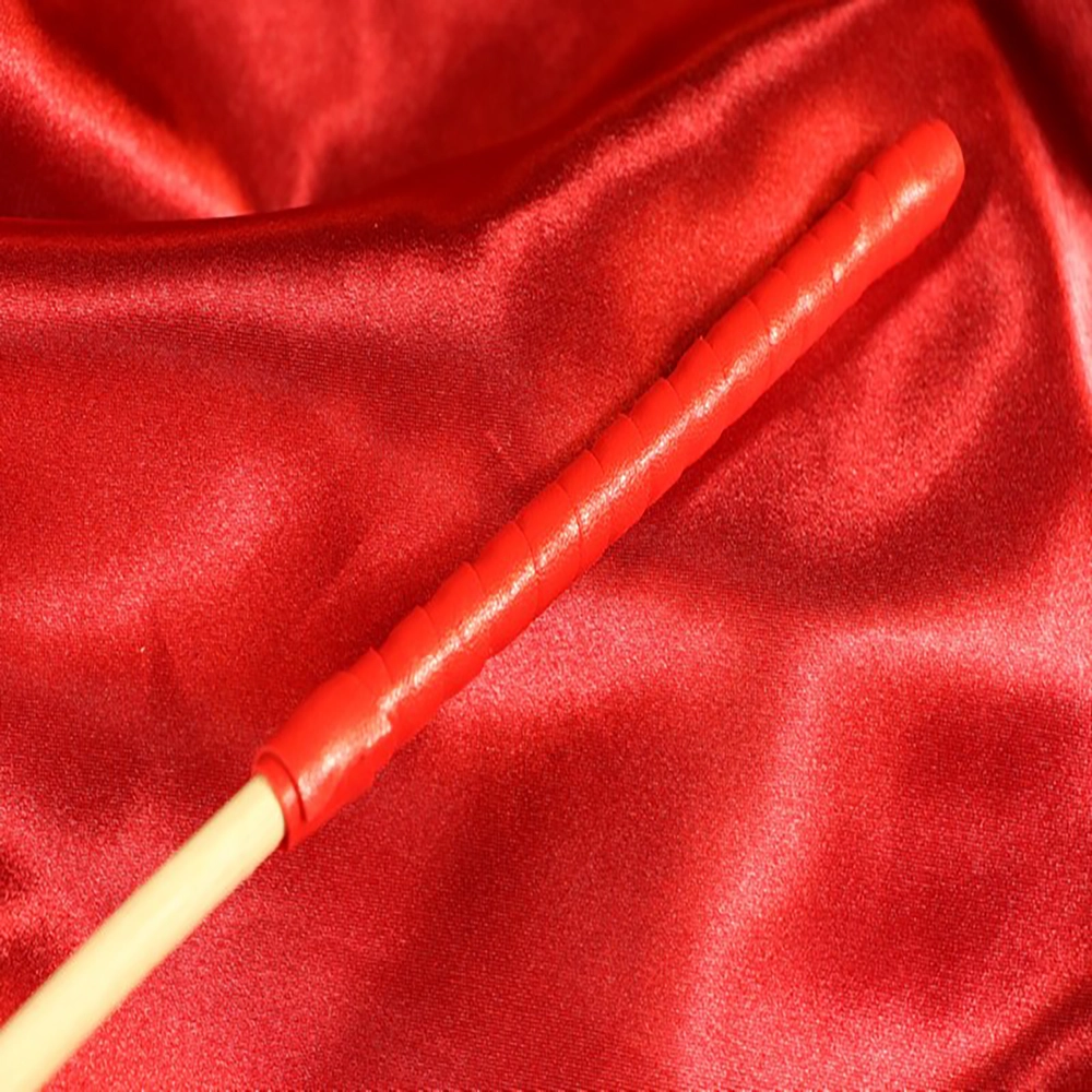 Close-up of the red handle of the Single Rotting Cane from Chambers of Love – classic discipline tool for BDSM sessions.