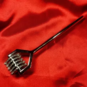 Five-row Wartenberg wheel from Chambers of Love, seen from above against a red background, highlighting the five rows of pins and the satin-polished steel surface.
