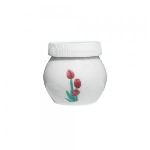 Dappenglas i vitt porslin med tulpaner på, inklusive vitt plastlock. 4 x 4 cm.