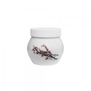 Dappenglas i vitt porslin med blommande körsbärskvistar på, inklusive vitt plastlock. 4 x 4 cm.