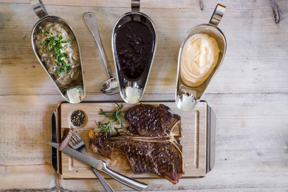 Planksteksbräda med underlägg av rostfritt stål ihop med såssnipor av rostfritt stål från Exxent.