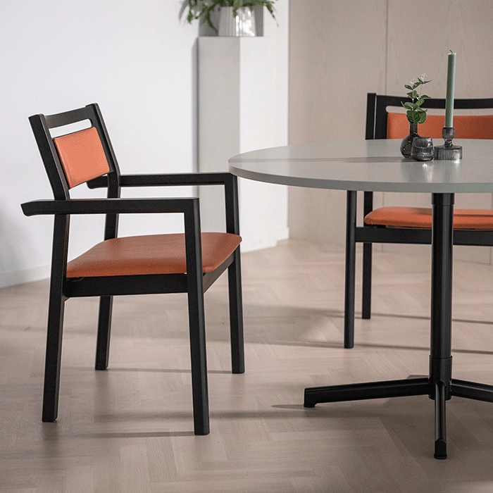 Alma XL karmstolar från Inoff med klädd sits och ryggdyna i en miljö.