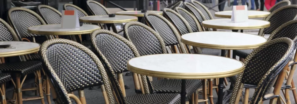 Bistro bordsskiva Marbre de Genes med mässingskant från Werzalit i en miljö med bistro bordsstativ.