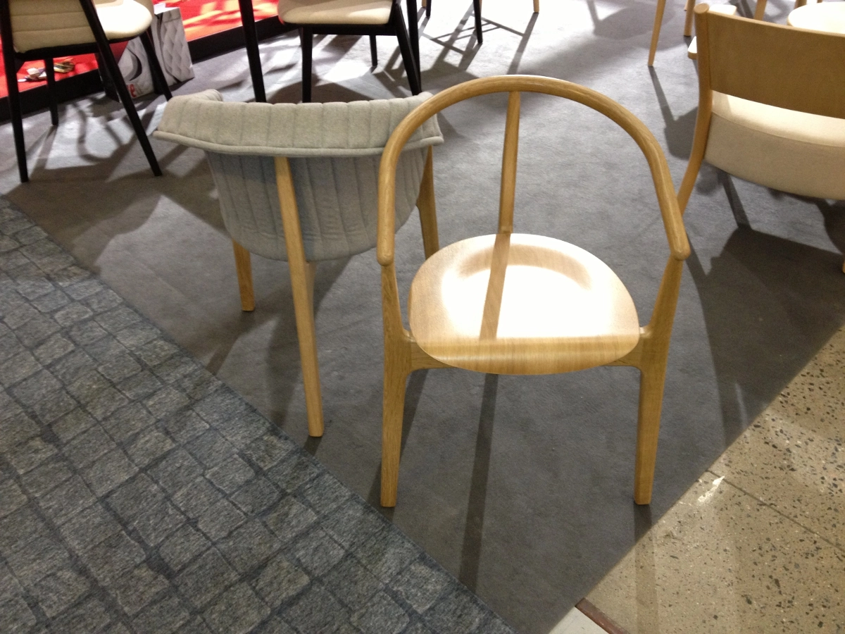 Evo karmstol med träsits och klädd från Paged Meble som har 3 ben.