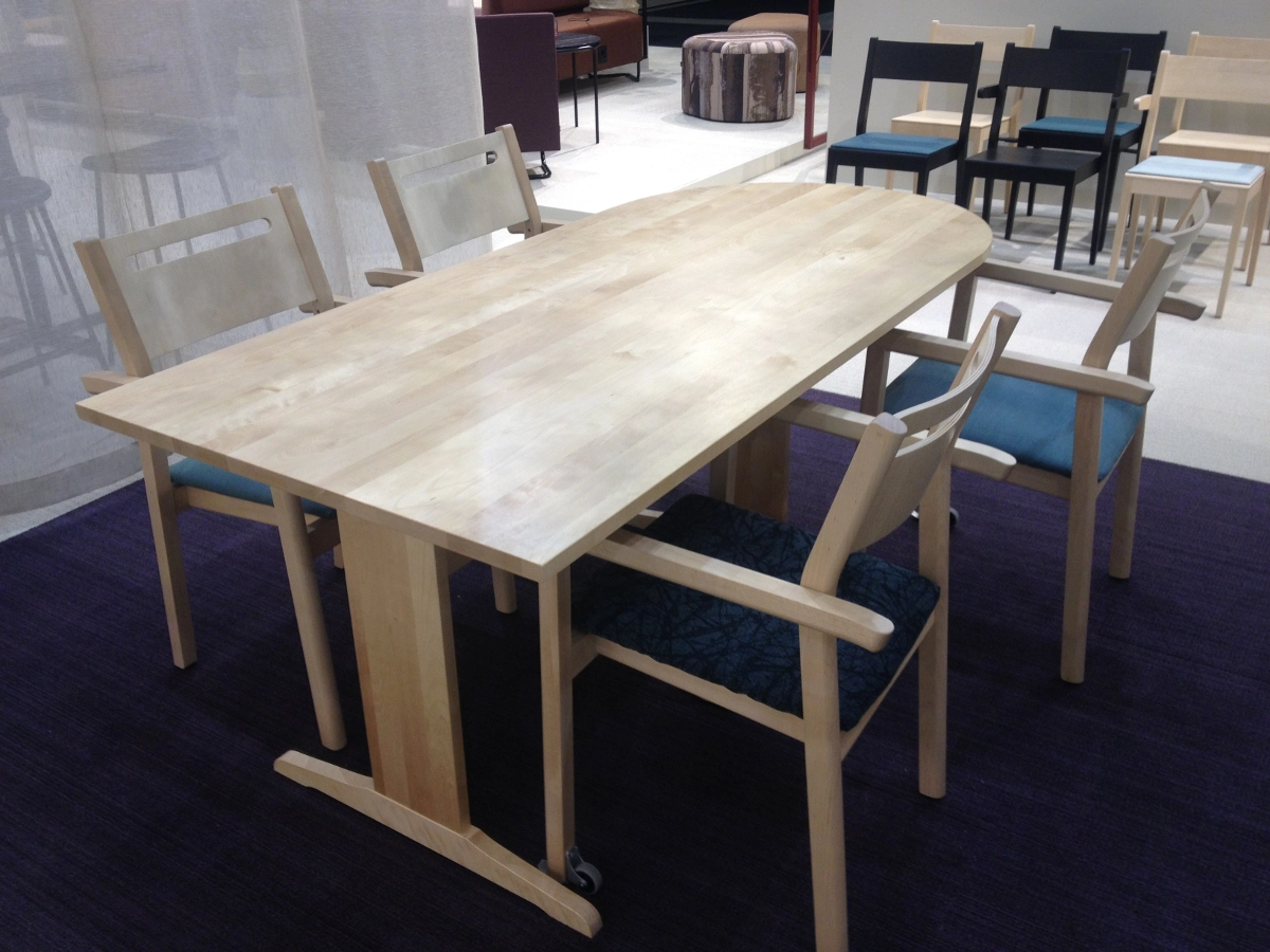 Alma karmstolar från Inoff med klädd sits ihop med Ester bord i en miljö.