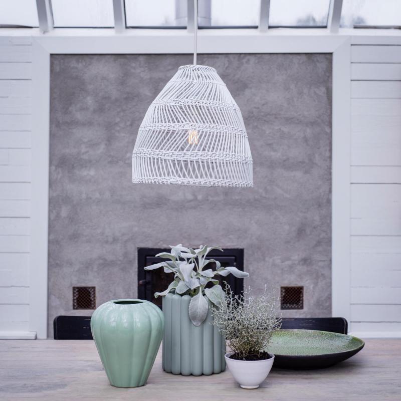 Vit lampa i rotting hänger över bord
