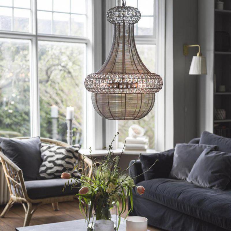 Saba – en modern ljuskrona hänger i taket framför fönster