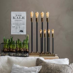 Stor svart adventsljusstake i industristil står på ett bord